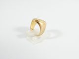 a close up of a gold ring on a white surface