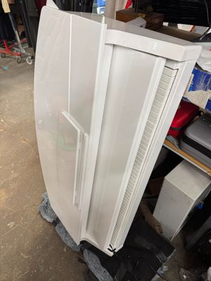 a white refrigerator sitting in a garage next to a pile of boxes
