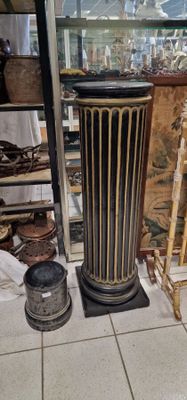un grand vase posé par terre à côté d'une chaise