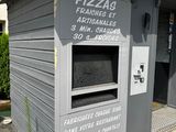 un four à pizza installé sur le mur d'un immeuble