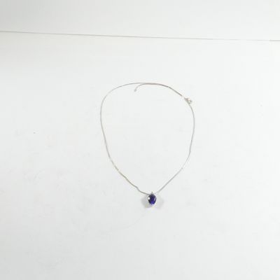 Le collier est composé de fil d'argent et de perles de verre bleues.