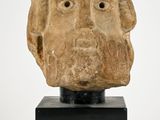 sculpture of a man ' s head on a black stand