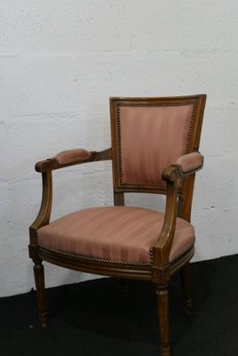une chaise en bois avec une assise rembourrée rose