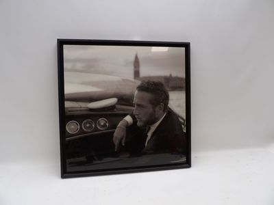 photographie en noir et blanc d'un homme assis dans une voiture avec une planche de surf