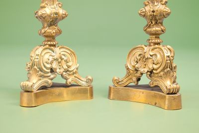 two gold colored candlesticks on a green background
