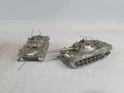 two toy tanks that are sitting side by side on a table