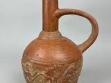 an old brown vase with a handle on a white surface