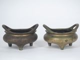paire de pots en bronze avec des anses et des pieds, sur fond blanc