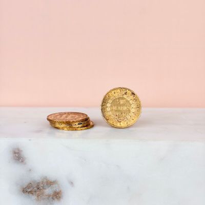 two gold coins sitting on top of a marble slab