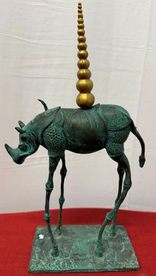 statue of a rhino with a golden horn on top of it ' s head