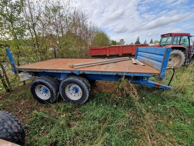 une remorque bleue garée dans l'herbe