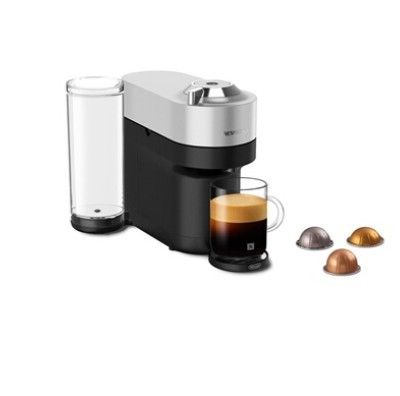 gros plan d'une tasse de café à côté d'une cafetière