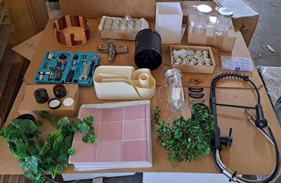 une table sur laquelle se trouvent de nombreux objets et qui est posée sur une autre table