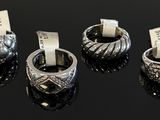 trois bagues munies d'étiquettes, posées sur une surface noire