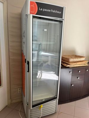 un réfrigérateur qui se trouve dans le coin d'une pièce