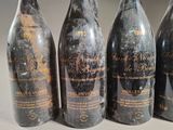 six bottles of wine are lined up on a table