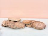a pile of coins sitting on a table next to a cup of coffee