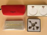 a red case with a pair of earrings and a pair of cuff watches