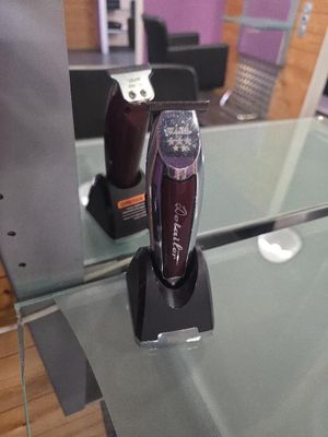 une tondeuse à cheveux posée sur une table en verre devant un miroir