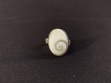 a close up of a white stone ring on a black surface