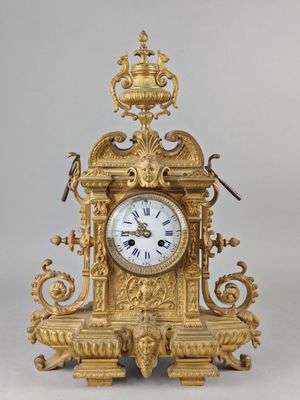 a gold clock with a bird on top of it