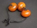trois tomates suspendues à une ficelle posée sur une table