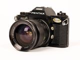 a black camera with a black lens on a white background