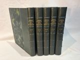 five black books are lined up in a row on a white surface