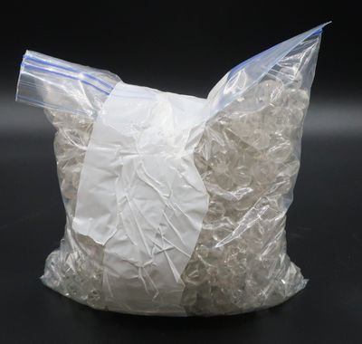 un sachet de riz blanc concassé posé sur une surface noire