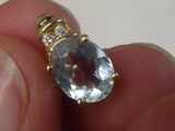 une personne tenant une bague sertie d'une topaze bleue