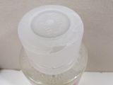 a bottle of liquid sitting on top of a toilet seat