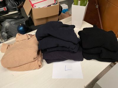une pile de vêtements posée sur une table à côté d'une boîte