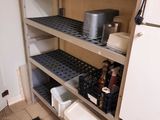une cuisine équipée d'un réfrigérateur et d'étagères sur lesquelles sont rangées des casseroles et des poêles