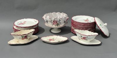 Plusieurs assiettes et tasses en porcelaine sont disposées sur une surface grise