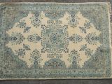 a close up of a blue and white rug on a floor
