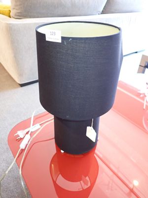 une table rouge sur laquelle est posée une lampe noire