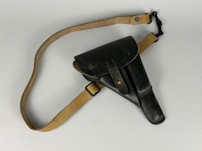 un vieil étui en cuir muni d'une lanière en cuir, sur fond blanc