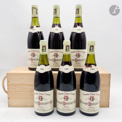 six bouteilles de vin sont posées dans une caisse en bois sur une surface blanche