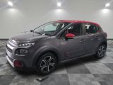 Une Citroën grise et rouge est garée dans un garage