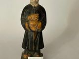 figurine représentant un moine tenant un bébé dans ses bras