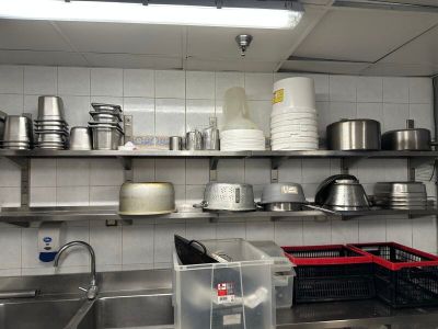 de nombreuses casseroles et poêles sur les étagères de la cuisine