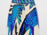 un vase bleu orné d'une girafe sur fond blanc