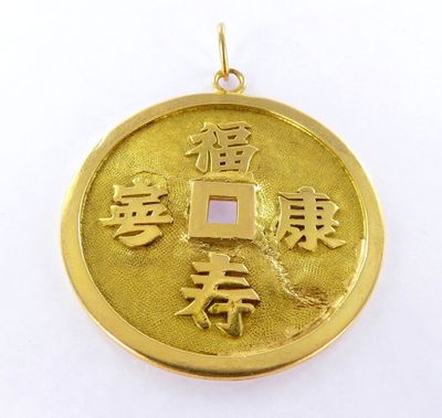 a close up of a gold coin with chinese writing on it