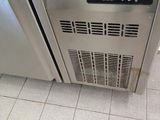 a stainless steel refrigerator with a digital clock on the door