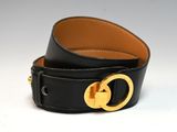 un gros plan sur une ceinture en cuir noir dotée d'une boucle dorée