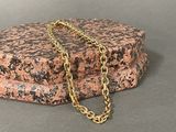 a gold chain that is laying on top of a rock