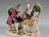 figurine représentant une famille assise sur une chaise avec un chien