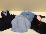 several children ' s clothes are lined up on a white table