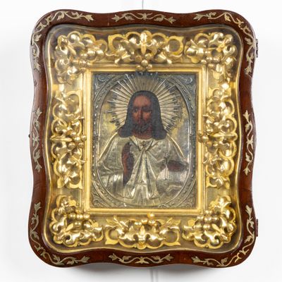 une vieille image de Jésus dans un cadre doré accrochée à un mur blanc