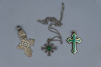 trois croix différentes et un pendentif en forme de croix sur un fond blanc